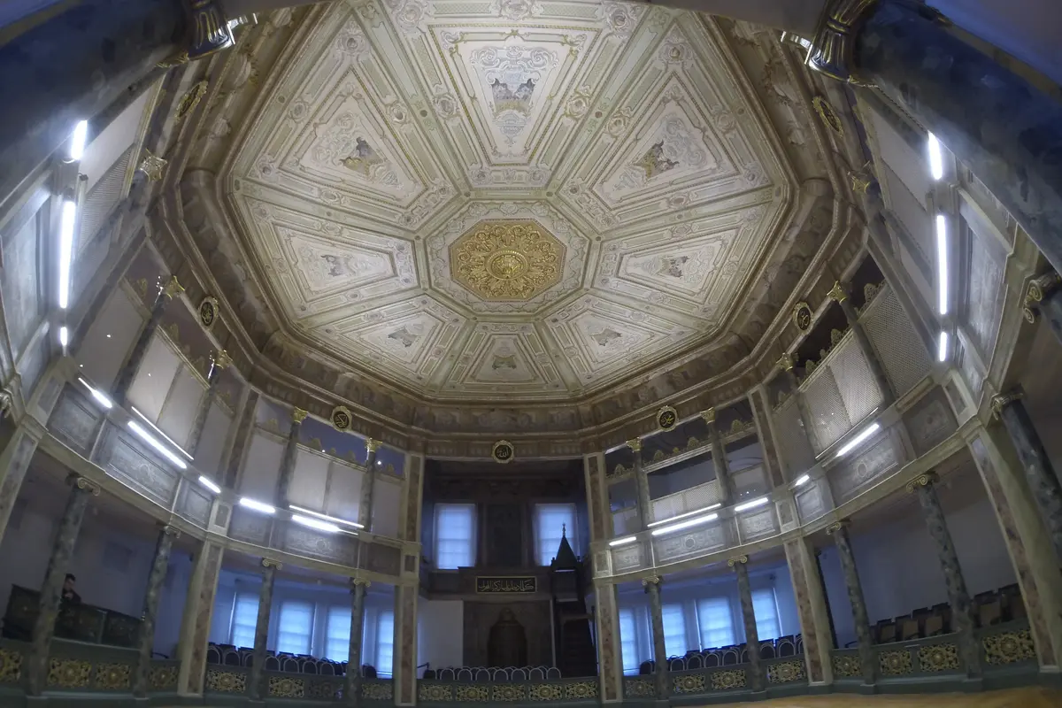 The octagonal ceremonial hall of the Galata Mevlevi Lodge, with a painted ceiling, two galleries on slender columns and a wooden floor